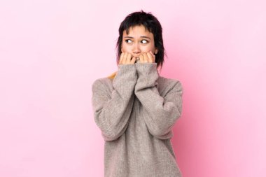 Genç Uruguaylı kadın izole pembe arka planda gergin ve korkmuş, elleriyle suni teneffüs yapıyor