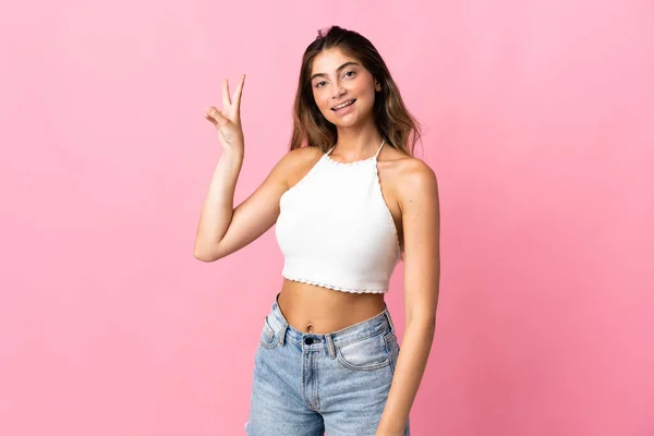 Jonge Kaukasische Vrouw Geïsoleerd Roze Achtergrond Glimlachen Tonen Overwinning Teken — Stockfoto