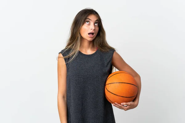 Молодая Женщина Играет Баскетбол Изолированы Белом Фоне Глядя Вверх Удивленным — стоковое фото
