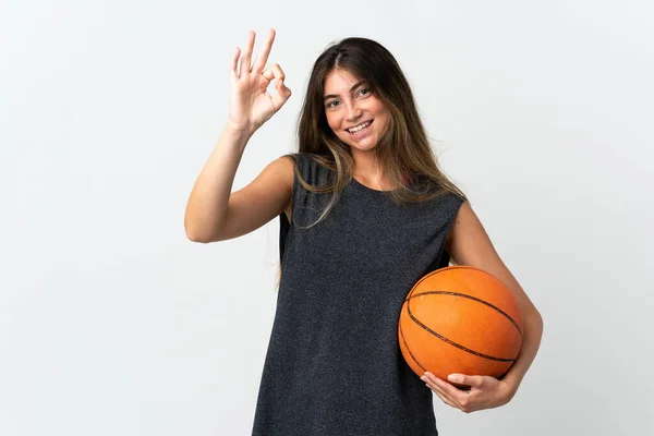 年轻女子打篮球是在白种人的背景下进行的 她的手指头显示出了好的手势 — 图库照片