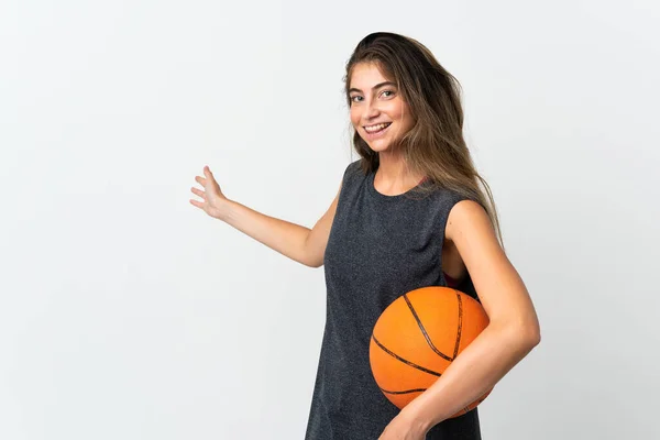 若いです女性プレイバスケットボールは白い背景に手を伸ばします側に招待するために来る — ストック写真