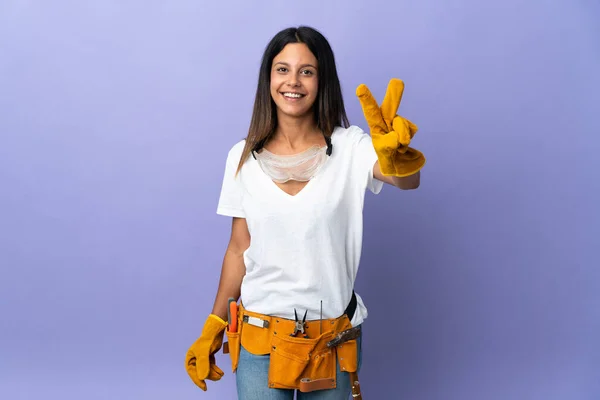 Junge Elektrikerin Auf Lila Hintergrund Isoliert Lächelnd Und Zeigt Siegeszeichen — Stockfoto