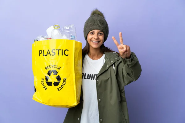 Young Woman Holding Bag Full Plastic Smiling Showing Victory Sign — Stock Photo, Image