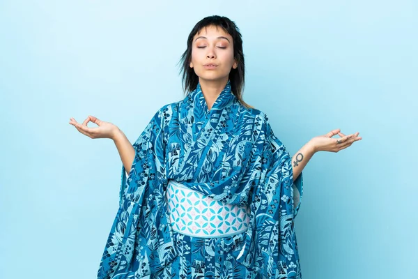 Молодая Женщина Кимоно Изолированном Синем Фоне Позе Дзен — стоковое фото