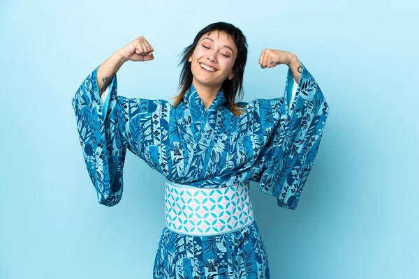 Młoda Kobieta Ubrana Kimono Odizolowanym Niebieskim Tle Robi Silny Gest — Zdjęcie stockowe