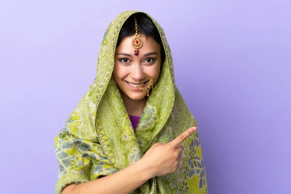Індійська Жінка Ізольована Пурпуровому Фоні Вказуючи Бік Щоб Представити Продукт — стокове фото