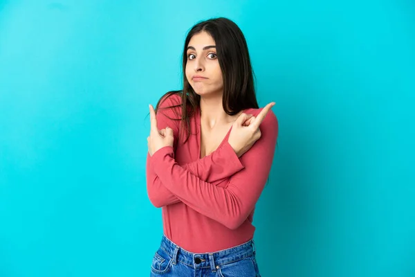 Young Caucasian Woman Isolated Blue Background Pointing Laterals Having Doubts — Stock Photo, Image
