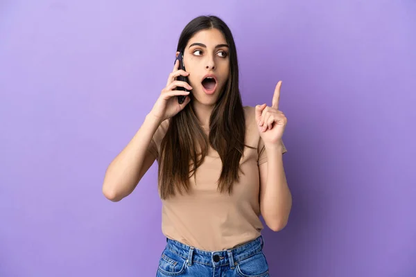 Молодая Белая Женщина Используя Мобильный Телефон Изолирован Фиолетовом Фоне Думая — стоковое фото