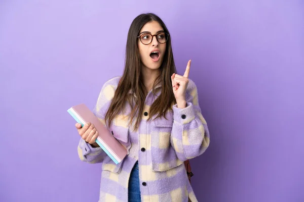 Jovem Estudante Mulher Isolada Fundo Roxo Pensando Uma Ideia Apontando — Fotografia de Stock