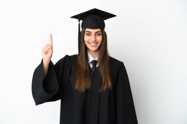 Beyaz arka planda izole edilmiş genç üniversite mezunu harika bir fikre işaret ediyor.