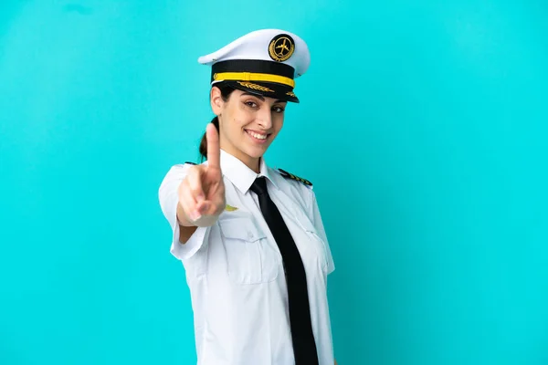 Pilot Samolot Biały Kobieta Odizolowany Niebieski Tło Pokazując Podnosząc Palec — Zdjęcie stockowe