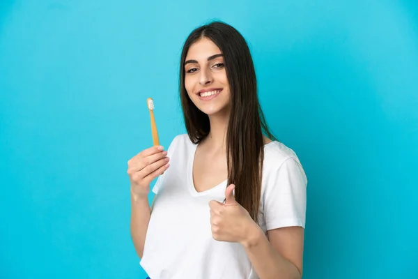 Młoda Biała Kobieta Myje Zęby Niebieskim Tle Kciukami Górze Stało — Zdjęcie stockowe