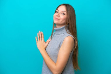 Genç Litvanyalı kadın mavi arka planda bir şeyler planlıyor.