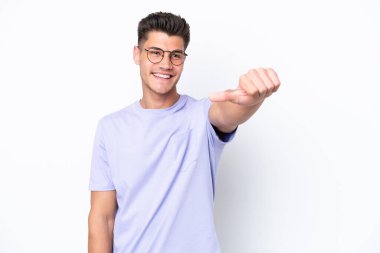 Beyaz arka planda izole edilmiş genç beyaz bir adam baş parmak hareketi yapıyor.