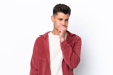 Beyaz arka planda soyutlanmış genç beyaz bir adamın şüpheleri var.