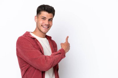 Beyaz arka planda izole genç beyaz adam geriye işaret ediyor