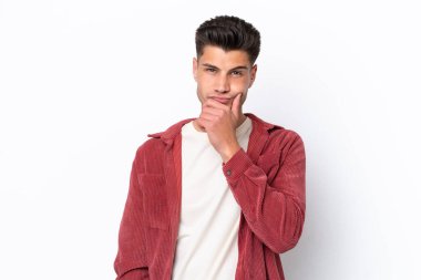 Beyaz arka planda soyutlanmış genç beyaz bir adamın şüpheleri var.