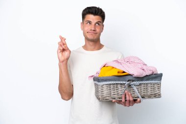 Beyaz arka planda çamaşır sepetini tutan beyaz tenli genç adam şans diliyor ve en iyisini diliyor.