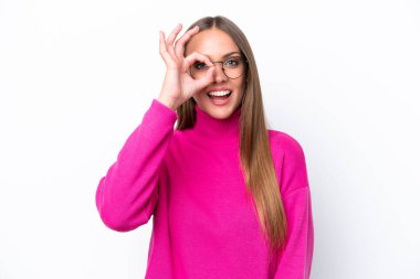 Beyaz arka planda izole edilmiş genç beyaz kadın parmaklarıyla tamam işareti gösteriyor.