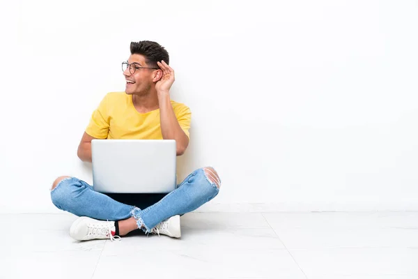 Giovane Seduto Sul Pavimento Isolato Sfondo Bianco Ascoltando Qualcosa Mettendo — Foto Stock