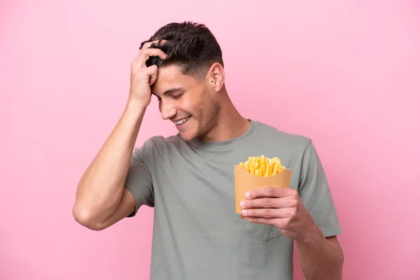 Młody Biały Mężczyzna Gospodarstwa Smażone Chipsy Izolowane Różowy Tło Śmiech — Zdjęcie stockowe