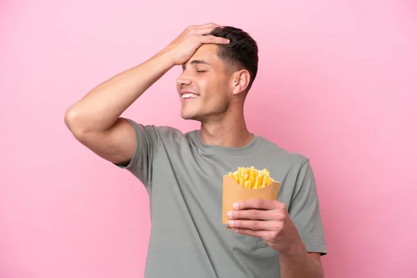 Jonge Blanke Man Met Gebakken Chips Geïsoleerd Roze Achtergrond Heeft — Stockfoto