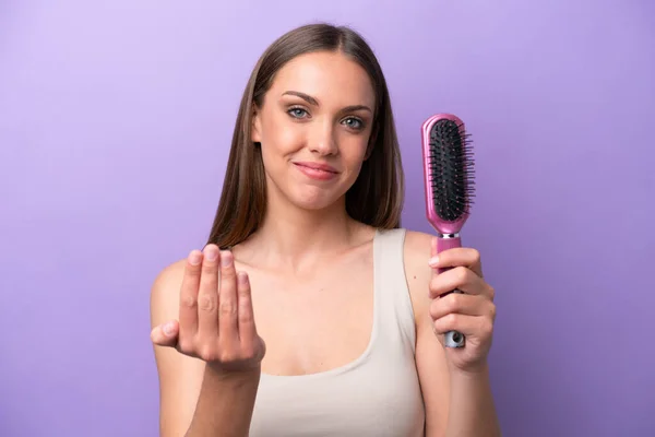 Mujer Caucásica Joven Sosteniendo Cepillo Aislado Sobre Fondo Púrpura Invitando —  Fotos de Stock