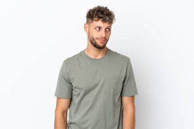 Beyaz arka planda izole edilmiş beyaz, yakışıklı genç bir adam şüpheli hareketler yapıyor.