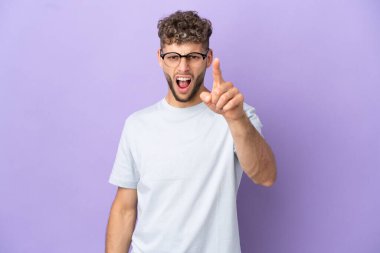 Mor arka planda izole edilmiş beyaz adam hayal kırıklığına uğramış ve ön tarafı işaret ediyor.