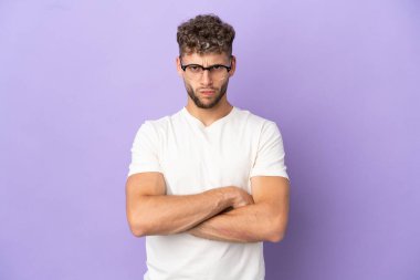 Mor arka planda, mutsuz bir ifadeyle izole edilmiş beyaz bir adam.