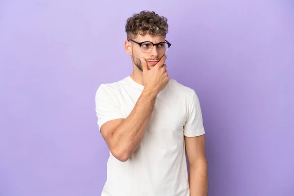 stock image Delivery caucasian man isolated on purple background having doubts and with confuse face expression