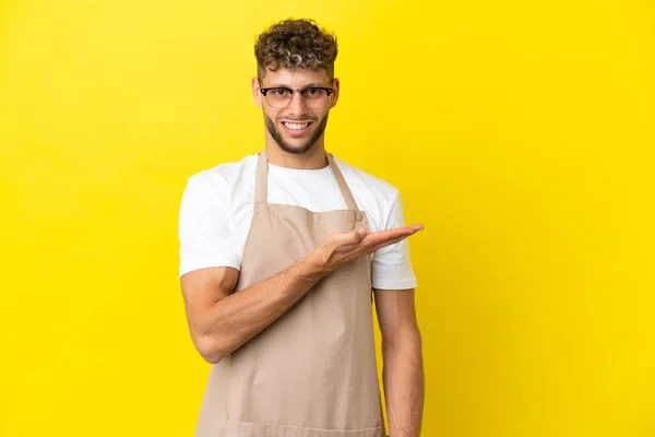 Restaurante Garçom Loiro Homem Isolado Fundo Amarelo Apresentando Uma Ideia — Fotografia de Stock