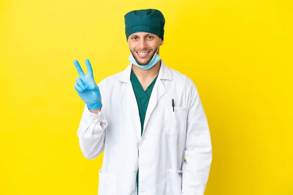 Χειρούργος Ξανθός Άνδρας Πράσινη Στολή Απομονωμένος Κίτρινο Φόντο Χαμογελώντας Και — Φωτογραφία Αρχείου