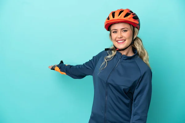 Giovane Ciclista Donna Isolata Sfondo Blu Allungando Mani Lato Invitare — Foto Stock