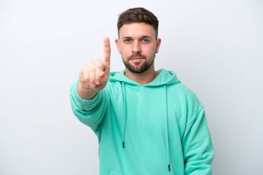 Beyaz arka planda izole edilmiş genç beyaz adam parmağını kaldırıyor ve gösteriyor.