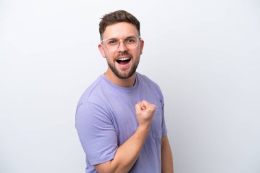 Beyaz arka planda izole edilmiş genç beyaz adam zaferi kutluyor.