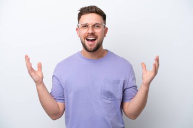 Beyaz arka planda izole edilmiş genç beyaz adam çok gülümsüyor.