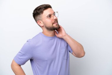 Beyaz arka planda izole edilmiş genç beyaz bir adam bir fikir düşünüyor.
