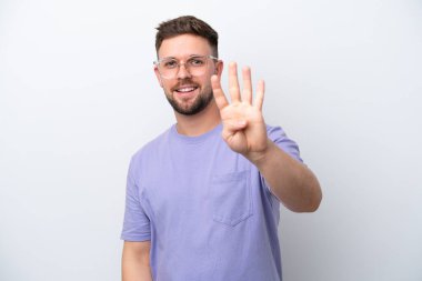 Beyaz arka planda izole edilmiş genç beyaz bir adam mutlu ve parmakları olan dört kişi sayıyor.