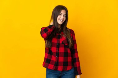 Genç Brezilyalı kız sarı arka planda izole edilmiş gülüyor.