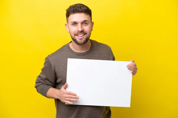 Ung Kaukasisk Man Isolerad Gul Bakgrund Håller Tom Skylt Med — Stockfoto