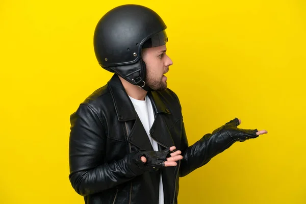 Junger Kaukasischer Mann Mit Motorradhelm Auf Gelbem Hintergrund Mit Überraschendem — Stockfoto