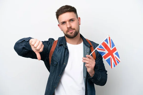 年轻的高加索男子举着一面英国国旗 白色背景孤立 带着负面表情垂下大拇指 — 图库照片