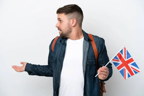 年轻的高加索人 手持一面白色背景的英国国旗 面带微笑地看着旁边 — 图库照片