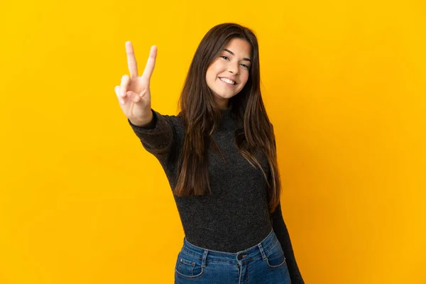 Adolescente Menina Brasileira Isolada Fundo Amarelo Sorrindo Mostrando Sinal Vitória — Fotografia de Stock