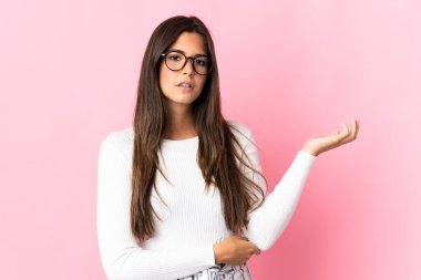 Pembe arka planda izole edilmiş genç Brezilyalı kadının şüpheleri var.