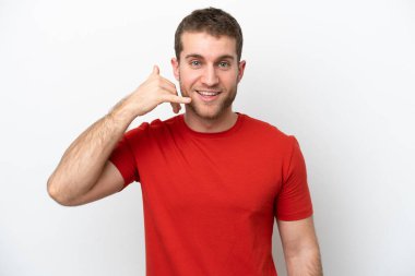 Beyaz arka planda izole edilmiş genç beyaz bir adam telefon jesti yapıyor. Bana geri dönüş işareti ver.