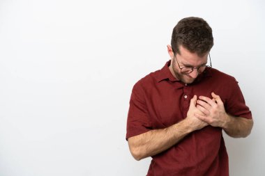 Beyaz arka planda izole edilmiş genç beyaz bir adam kalbinde bir ağrı var.