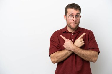 Beyaz arka planda izole edilmiş beyaz tenli genç adam, yan taraftakilerin şüphelerine işaret ediyor.