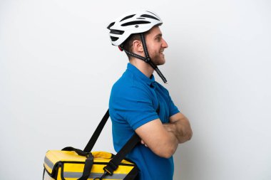 Beyaz arka planda, termal sırt çantalı beyaz tenli genç bir adam var.